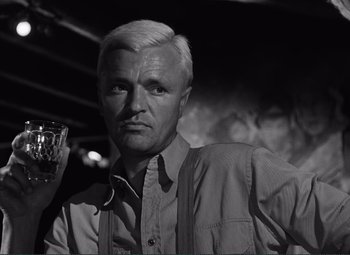 Movie still from “The Wages of Fear” (1953), directed by Henri-Georges Clouzot – An older man with white hair is holding a glass; Close Up shot, Low angle