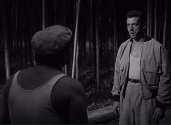 Movie still from “The Wages of Fear” (1953), directed by Henri-Georges Clouzot – A man and a woman in the woods talking to each other; Medium shot, Over the shoulder angle
