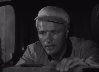 Movie still from “The Wages of Fear” (1953), directed by Henri-Georges Clouzot – An older man wearing a hat and looking at the camera; Close Up shot, Low angle
