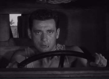 Movie still from “The Wages of Fear” (1953), directed by Henri-Georges Clouzot – A black and white photo of a man driving a car; Close Up shot, Low angle