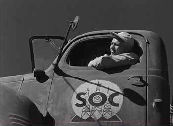 Movie still from “The Wages of Fear” (1953), directed by Henri-Georges Clouzot – A black and white photo of a man sitting in the driver's seat of an old truck; Medium shot, Low angle