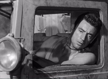 Movie still from “The Wages of Fear” (1953), directed by Henri-Georges Clouzot – A black - and - white photo of a man looking out of a car window; Close Up shot, High angle