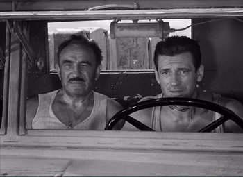 Movie still from “The Wages of Fear” (1953), directed by Henri-Georges Clouzot – A black and white photo of two men in a truck; Medium shot, High angle