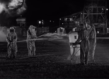 Movie still from “The Wages of Fear” (1953), directed by Henri-Georges Clouzot – A black and white photo of a group of people spraying water; Extreme Wide shot, High angle