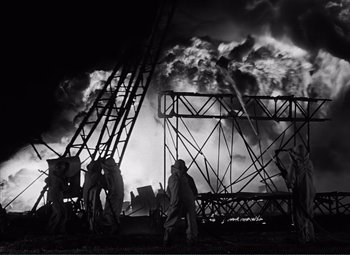 Movie still from “The Wages of Fear” (1953), directed by Henri-Georges Clouzot – Black and white photograph of people working on a fire; Extreme Wide shot, Low angle