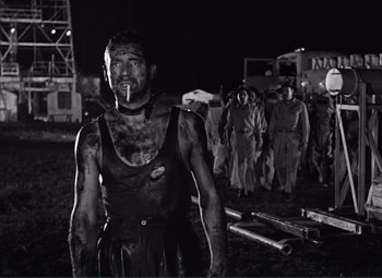 Movie still from “The Wages of Fear” (1953), directed by Henri-Georges Clouzot – Black and white photograph of a man with a cigarette in his mouth; Medium shot, Low angle