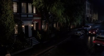 Movie still from “The War of the Roses” (1989), directed by Danny DeVito – A car parked on the side of the street at night; Extreme Wide shot, High angle