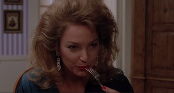 Movie still from “The War of the Roses” (1989), directed by Danny DeVito – A person holding a fork in her mouth; Close Up shot, Low angle