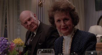 Movie still from “The War of the Roses” (1989), directed by Danny DeVito – An older man sitting next to an older woman at a table; Close Up shot, Over the shoulder angle