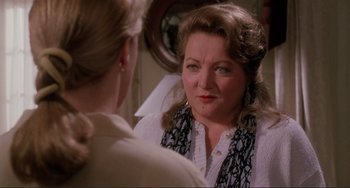 Movie still from “The War of the Roses” (1989), directed by Danny DeVito – An older woman looking in the reflection of a mirror; Close Up shot, Over the shoulder angle