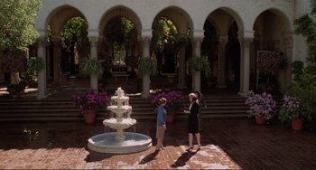 Movie still from “The War of the Roses” (1989), directed by Danny DeVito – Two women are standing in front of a fountain; Extreme Wide shot, High angle