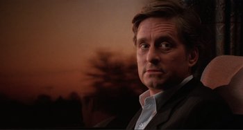 Movie still from “The War of the Roses” (1989), directed by Danny DeVito – A person wearing a suit and tie; Close Up shot, Low angle