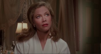 Movie still from “The War of the Roses” (1989), directed by Danny DeVito – A woman with long blonde hair looking up at the sky; Close Up shot, Over the shoulder angle