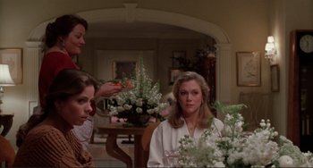 Movie still from “The War of the Roses” (1989), directed by Danny DeVito – A group of people sitting around a table; Medium shot, Low angle