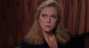 Movie still from “The War of the Roses” (1989), directed by Danny DeVito – A person with long blonde hair; Close Up shot, Over the shoulder angle