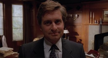 Movie still from “The War of the Roses” (1989), directed by Danny DeVito – A person wearing a suit and tie; Close Up shot, Low angle