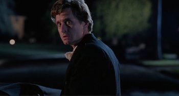 Movie still from “The War of the Roses” (1989), directed by Danny DeVito – A person wearing a suit and tie; Close Up shot, Low angle