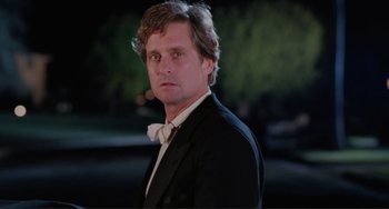 Movie still from “The War of the Roses” (1989), directed by Danny DeVito – A man in a suit and a bow tie; Close Up shot, Low angle