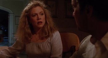 Movie still from “The War of the Roses” (1989), directed by Danny DeVito – A woman sitting at a table talking to a man; Close Up shot, Over the shoulder angle