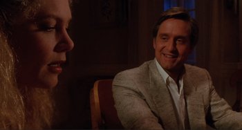 Movie still from “The War of the Roses” (1989), directed by Danny DeVito – A man and a woman are sitting in a chair; Close Up shot, Over the shoulder angle