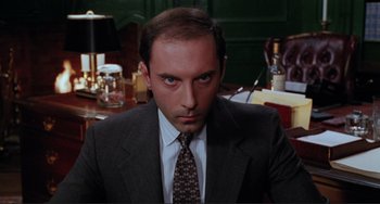 Movie still from “The War of the Roses” (1989), directed by Danny DeVito – A person wearing a suit and tie; Close Up shot, Low angle