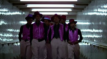 Movie still from “The Warriors” (1979), directed by Walter Hill – A group of young men standing next to each other; Medium shot, Low angle