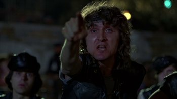 Movie still from “The Warriors” (1979), directed by Walter Hill – A man in a leather vest is pointing at the camera; Close Up shot, Low angle