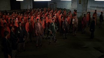 Movie still from “The Warriors” (1979), directed by Walter Hill – A large group of men in orange shirts and hats; Wide shot, High angle