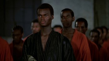 Movie still from “The Warriors” (1979), directed by Walter Hill – A group of men standing next to each other in robes; Close Up shot, Low angle