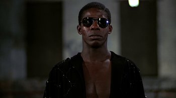 Movie still from “The Warriors” (1979), directed by Walter Hill – A man wearing a black jacket and sunglasses; Close Up shot, Low angle