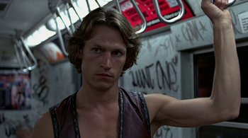 Movie still from “The Warriors” (1979), directed by Walter Hill – A man with long blonde hair wearing a leather vest; Close Up shot, Low angle