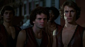 Movie still from “The Warriors” (1979), directed by Walter Hill – A group of men standing next to each other; Close Up shot, Low angle