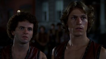 Movie still from “The Warriors” (1979), directed by Walter Hill – A couple of men standing next to each other in a room; Close Up shot, Low angle
