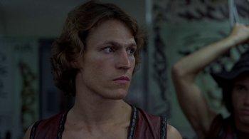 Movie still from “The Warriors” (1979), directed by Walter Hill – A man with long brown hair looking into a mirror; Close Up shot, Over the shoulder angle
