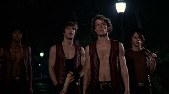 Movie still from “The Warriors” (1979), directed by Walter Hill – A couple of men standing next to each other on a street; Medium shot, Low angle
