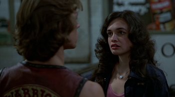 Movie still from “The Warriors” (1979), directed by Walter Hill – A woman is looking at a man in a purple shirt; Close Up shot, Over the shoulder angle