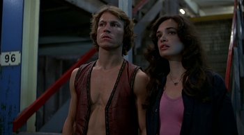 Movie still from “The Warriors” (1979), directed by Walter Hill – A man and a woman standing next to each other; Medium shot, Low angle