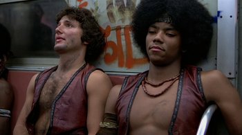 Movie still from “The Warriors” (1979), directed by Walter Hill – A couple of men sitting next to each other on a bench; Close Up shot, Low angle