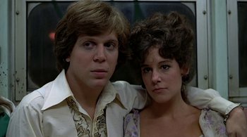 Movie still from “The Warriors” (1979), directed by Walter Hill – A man and a woman pose for a picture; Close Up shot, Low angle