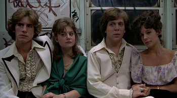 Movie still from “The Warriors” (1979), directed by Walter Hill – A man and a woman sitting next to each other on a train; Medium shot, Low angle