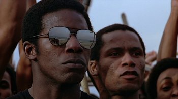 Movie still from “The Warriors” (1979), directed by Walter Hill – Two men wearing sunglasses are looking at the camera; Close Up shot, Low angle