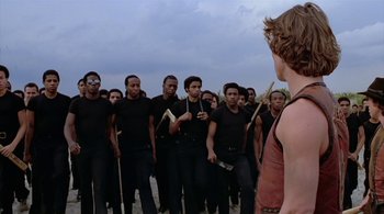 Movie still from “The Warriors” (1979), directed by Walter Hill – A group of men standing in a row in front of another man; Wide shot, High angle