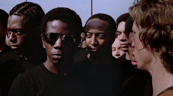 Movie still from “The Warriors” (1979), directed by Walter Hill – A group of men standing next to each other; Medium shot, Low angle