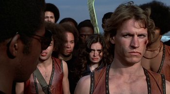 Movie still from “The Warriors” (1979), directed by Walter Hill – A group of people standing around each other; Close Up shot, Low angle