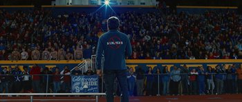Movie still from “The Watch” (2012), directed by Akiva Schaffer – A man standing in front of a crowd of people in a stadium; Wide shot, High angle
