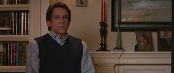 Movie still from “The Watch” (2012), directed by Akiva Schaffer – A man standing in front of a fireplace in a living room; Medium shot, Over the shoulder angle