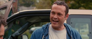 Movie still from “The Watch” (2012), directed by Akiva Schaffer – A man standing in front of a parked car; Close Up shot, Over the shoulder angle
