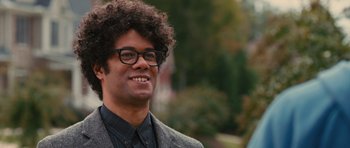 Movie still from “The Watch” (2012), directed by Akiva Schaffer – A person wearing glasses and a suit jacket; Close Up shot, Over the shoulder angle