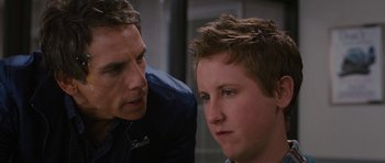 Movie still from “The Watch” (2012), directed by Akiva Schaffer – A man standing next to another man in a room; Close Up shot, Over the shoulder angle