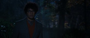 Movie still from “The Watch” (2012), directed by Akiva Schaffer – A man in a suit and glasses standing in the dark; Medium shot, Over the shoulder angle